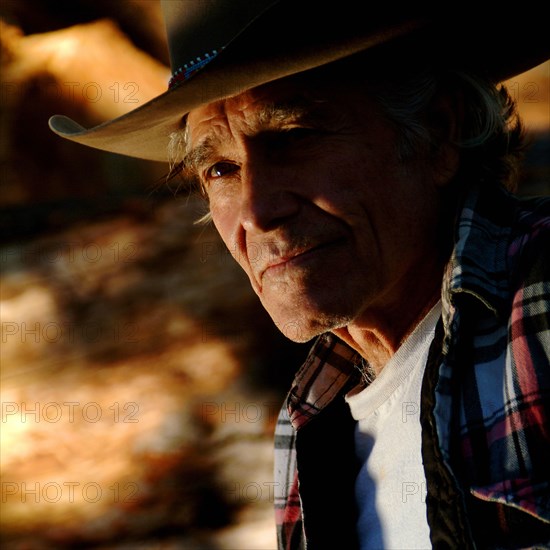 Man wearing cowboy hat looking at camera