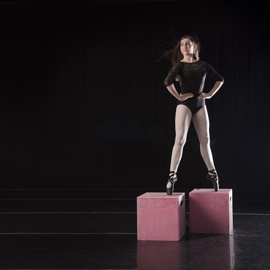 Caucasian ballet dancer balancing on pink boxes