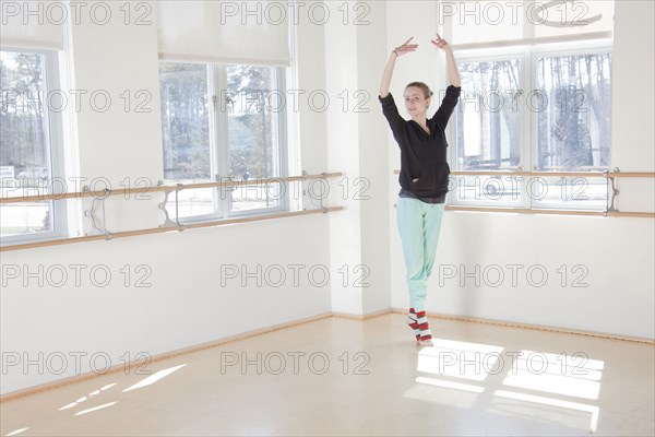 Caucasian ballerina practicing in studio