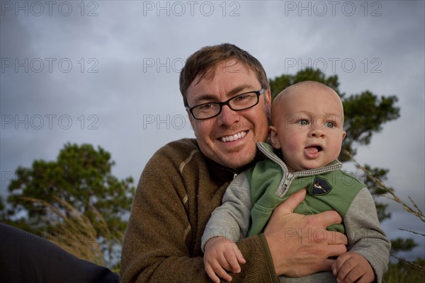 Portrait of smiling Caucasian father holding baby son