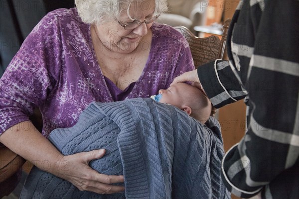 Caucasian grandmother holding baby grandson