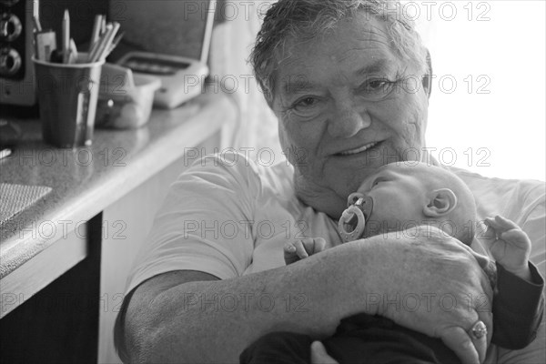 Caucasian grandfather holding baby grandson