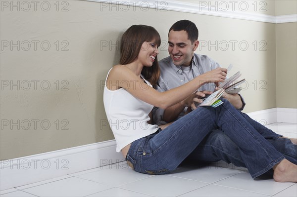 Hispanic husband and wife looking at color swatches