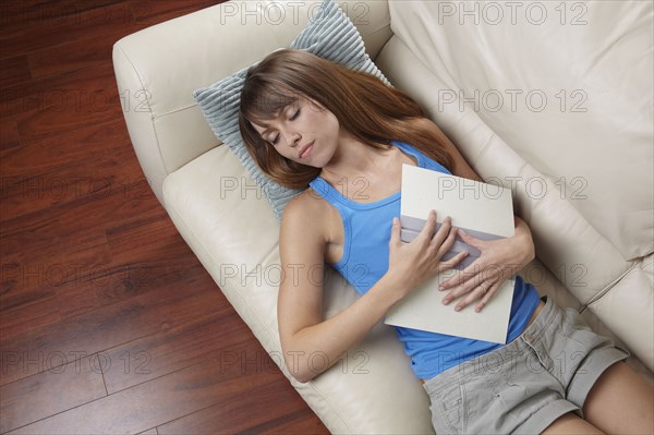 Mixed race woman sleeping on sofa