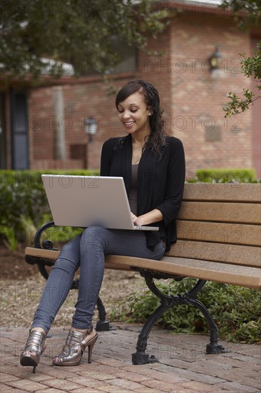 Mixed race woman typing on laptop