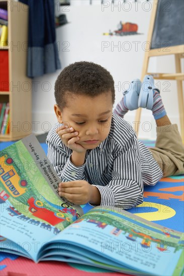 Mixed race boy reading storybook
