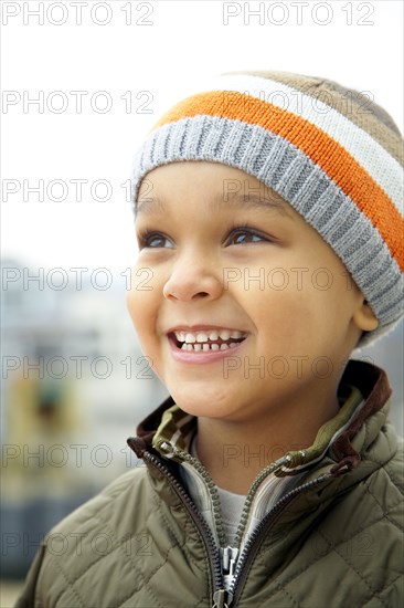 Mixed race boy in cap outdoors