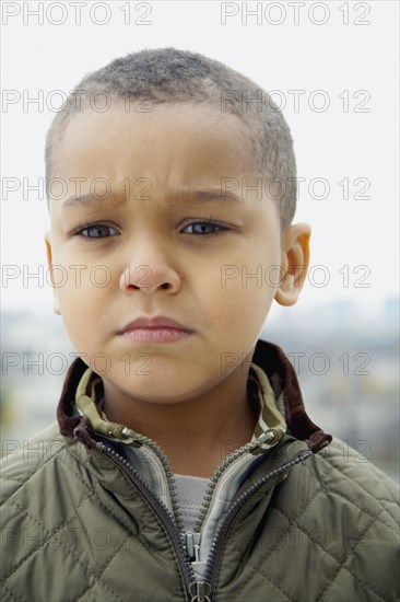 Mixed race boy frowning