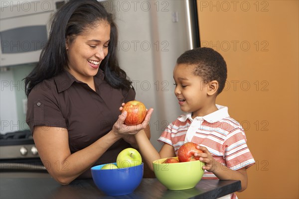 Dominican mother handing son an apple