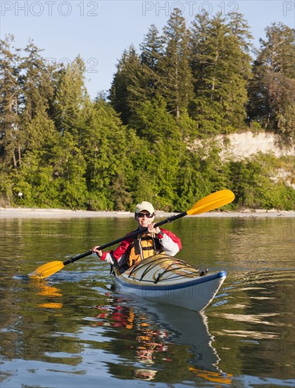 Hispanic woman kayaking on lake