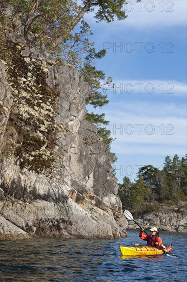 Hispanic woman kayaking on lake