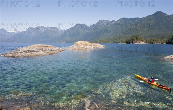 Hispanic woman kayaking on lake