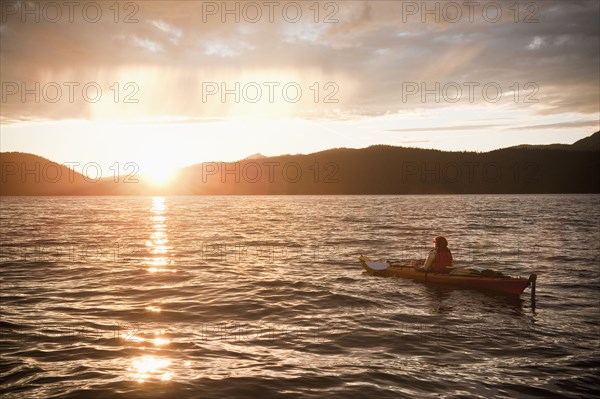 Hispanic woman kayaking on lake