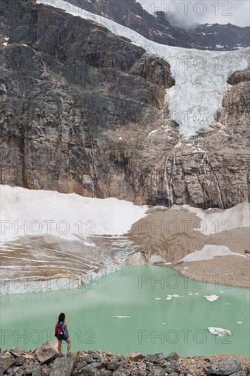 Hispanic woman hiking hear glacial lake