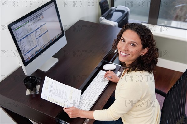 Hispanic woman paying bills on computer