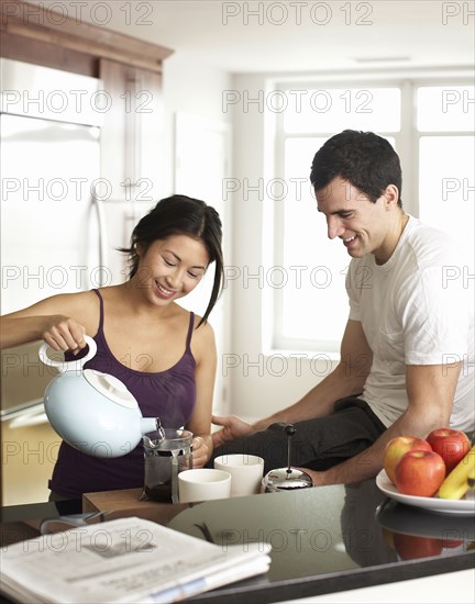 Couple preparing coffee in kitchen