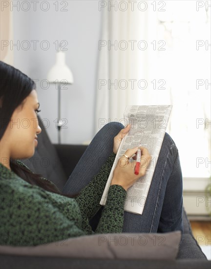 Woman reading classified ads in newspaper