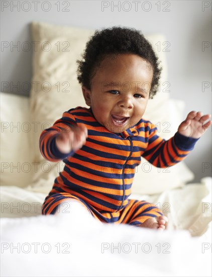 African American boy sitting on bed