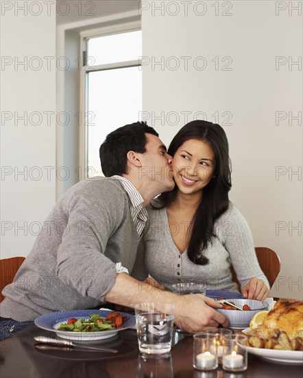 Husband kissing wife at dinner table