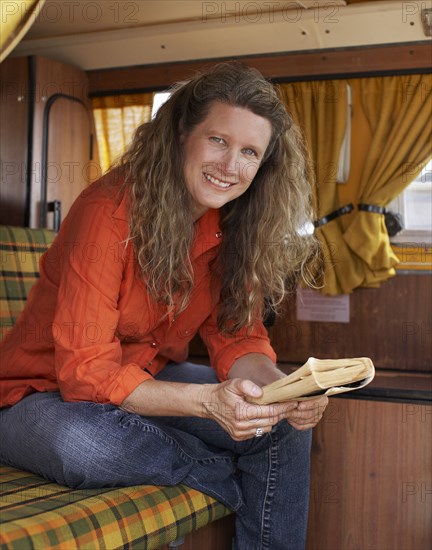 Caucasian woman reading book in camper