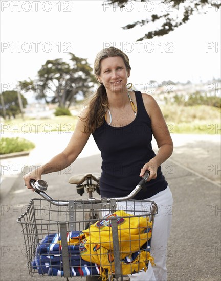 Caucasian woman pushing bicycle