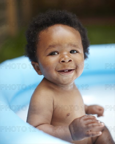 Smiling African American baby in swimming pool