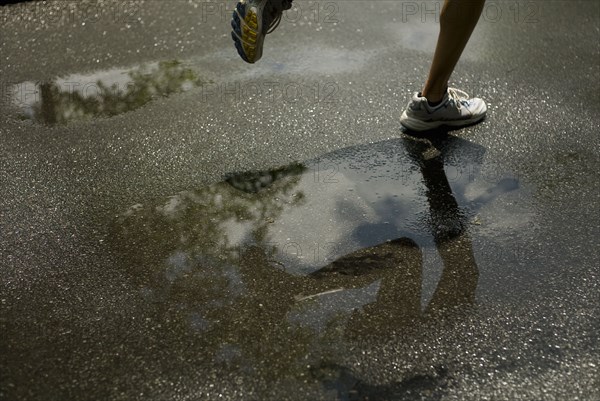 Woman running through puddle