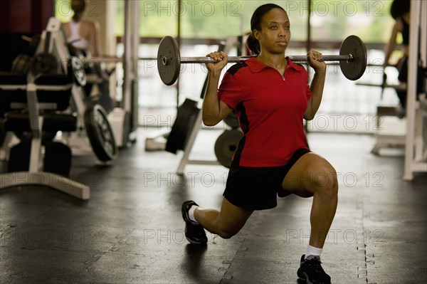 Woman weight lifting in health club