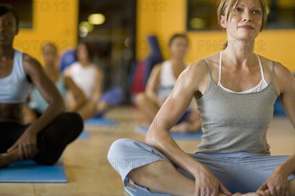 Women practicing yoga in health club