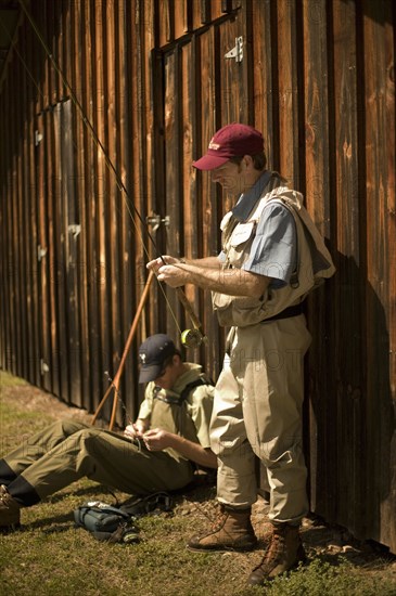 Men adjusting fishing rods