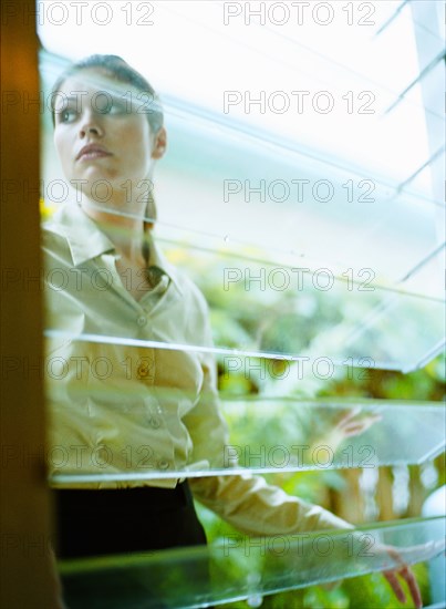 Woman behind window in greenhouse