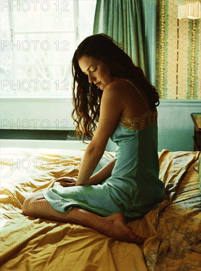 Caucasian woman sitting on bed