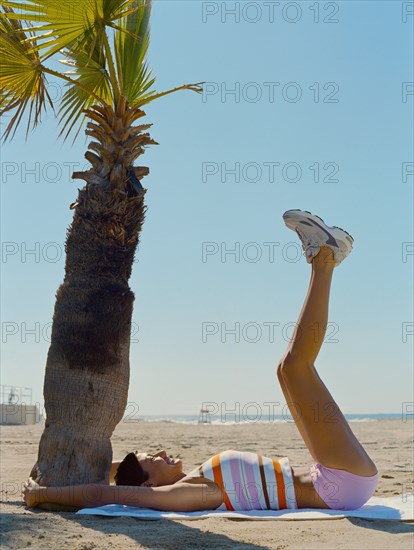 Mixed race woman exercising on beach