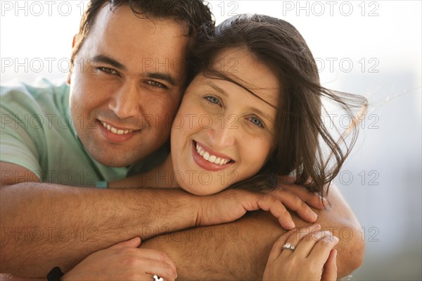 Close up of smiling Hispanic couple hugging