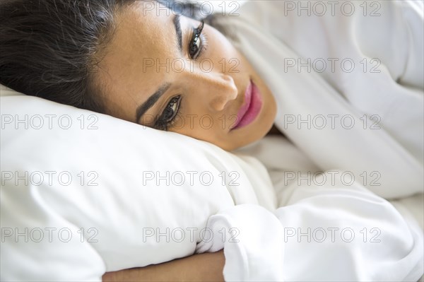 Hispanic woman laying in bed