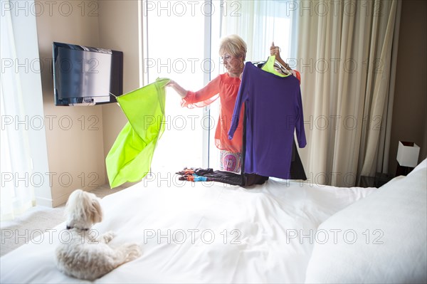 Older Caucasian woman choosing outfit in bedroom