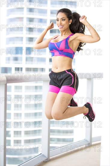 Hispanic athlete exercising on balcony