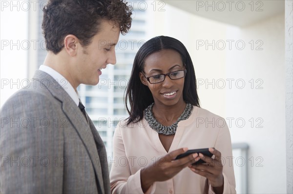 Business people using cell phone in office