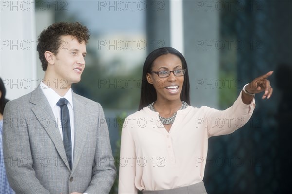 Business people gesturing in office lobby