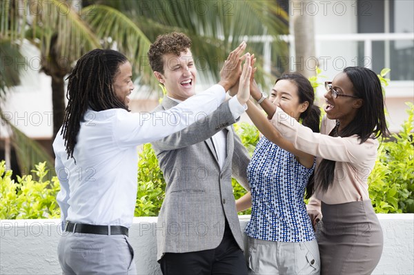 Business people high-fiving outdoors
