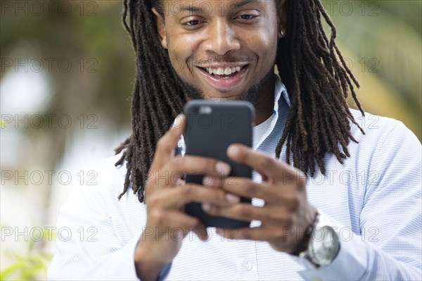 African American businessman using cell phone outdoors