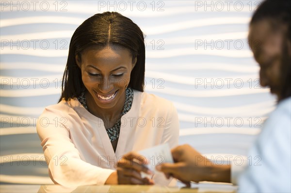 African American concierge checking guest into hotel