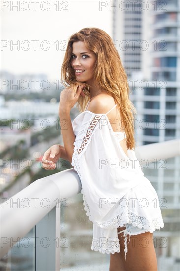 Hispanic woman standing on urban balcony