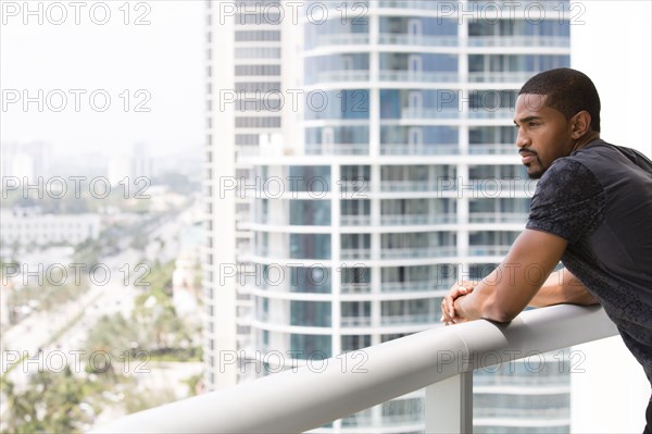 African American man standing on urban balcony