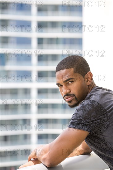 African American man standing on urban balcony