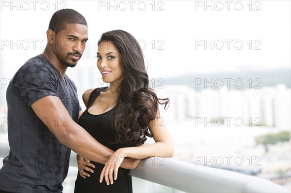 Couple hugging on balcony over cityscape