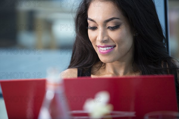 Hispanic woman using laptop in cafe