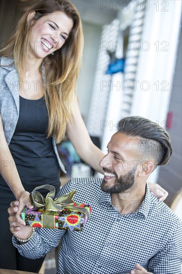 Hispanic woman giving boyfriend gift