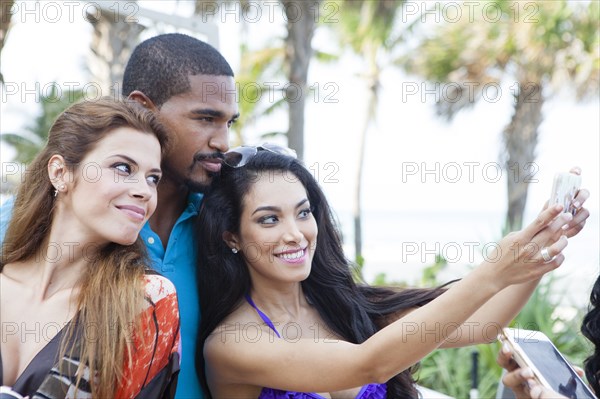 Friends taking selfie with cell phone outdoors