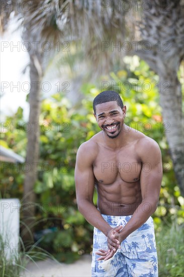 African American man wearing swim trunks on beach